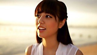 Slim Asian girl Yumi Sugimoto walks on a beach wearing white dress