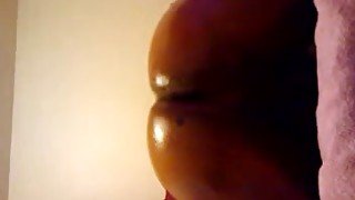 Lustful ebony chick oils up her bubbled ass and fucks it