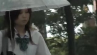 Asian schoolgirl gets street sharking on a rainy day.