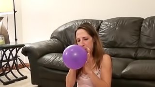 Solo Model Teen In Miniskirt Blowing Balloons In A Cozy Room