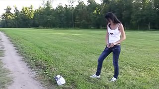 Skinny babe lies down on the grass and passionately masturbates pussy