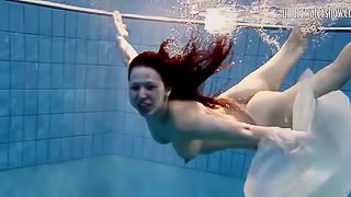 Long hair solo model blonde widening legs while diving in pool