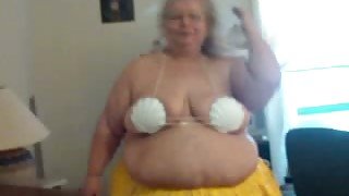 Obese grandma in glasses dances for me in Hawaiian skirt
