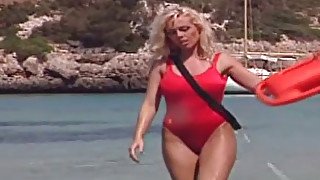 Saucy blond haired MILF in red swim suit performs steamy solo on sandy beach