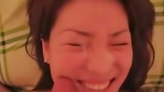 Pretty korean girl is filmed sucking a small cock and taking its cum all over her face.