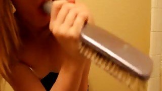 Teen blondie plays with a hairbrush and sticks it in her pussy