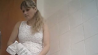 Fine curvaceous blonde lady in white dress filmed in the toilet room