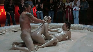 Two spoiled hussies and horny dude mess around in mud in front of people
