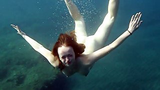 Cute redhead teen babe in the open blue sea underwater