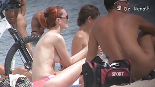 Cute blonde, redhead and brunette are lying naked on the beach