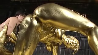 She is covered in gold paint then she gets fucked by a golden guy