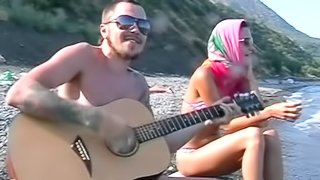 He plays guitar for her and fucks her on the beach