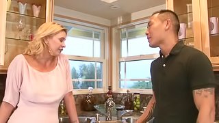 Tattooed Asian dude fucks a hot blonde milf in the kitchen