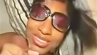 Black babe in sunglasses jacks off a cock