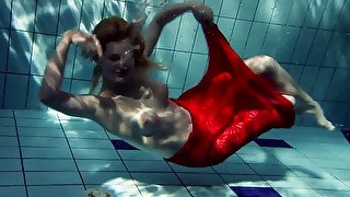 Blonde busty European teenie in red dress underwater